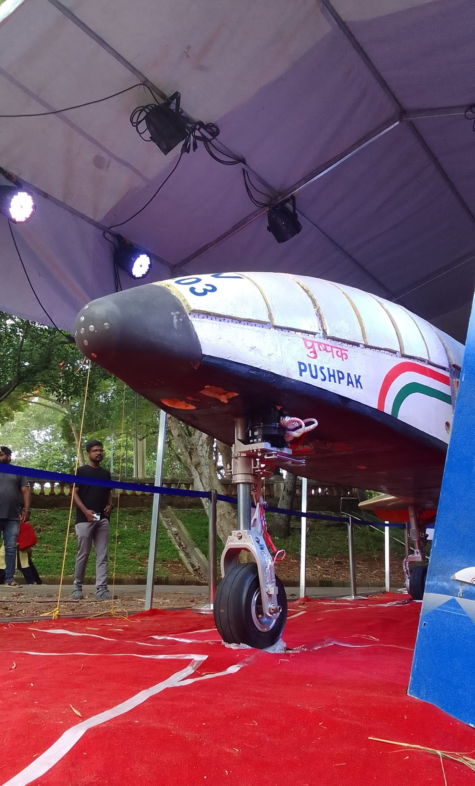 Pushpak RLV-TD nose section on public display, showing its winged lifting-body design and Indian tricolour livery